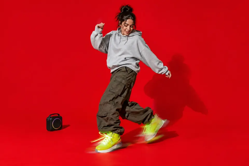Ein Tänzer in Neon-Turnschuhen beim schnellen Shuffle-Schritt, die Füße verwischt vor Bewegung